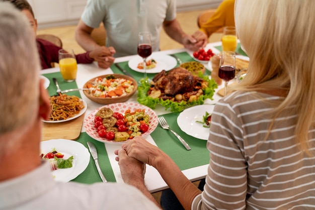 Happy family praying before having dinner together