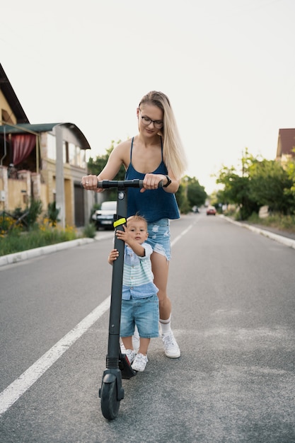 Happy family riding scooter in the neighborhood on the road.