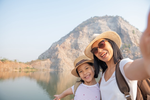 Foto gratuita famiglia felice in piedi vicino al lago