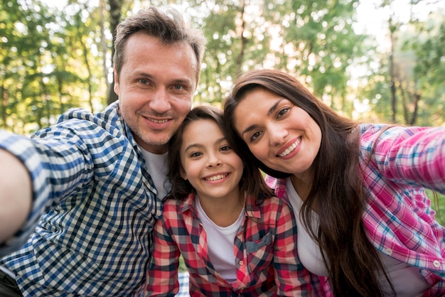 Foto gratuita famiglia felice prendendo selfie nel parco