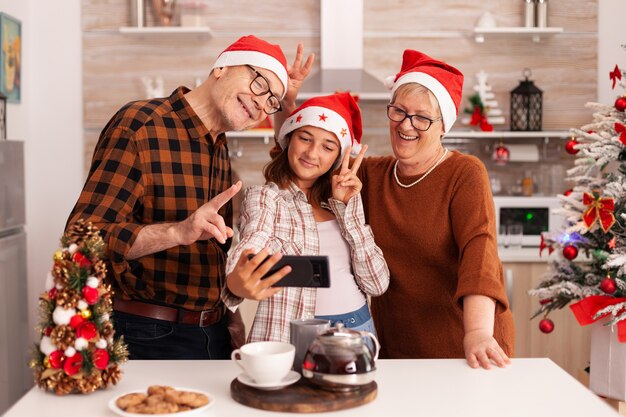 Happy family taking selfie using smartphone making funny expressions