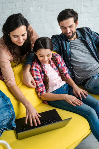 Free photo happy family using a laptop high view