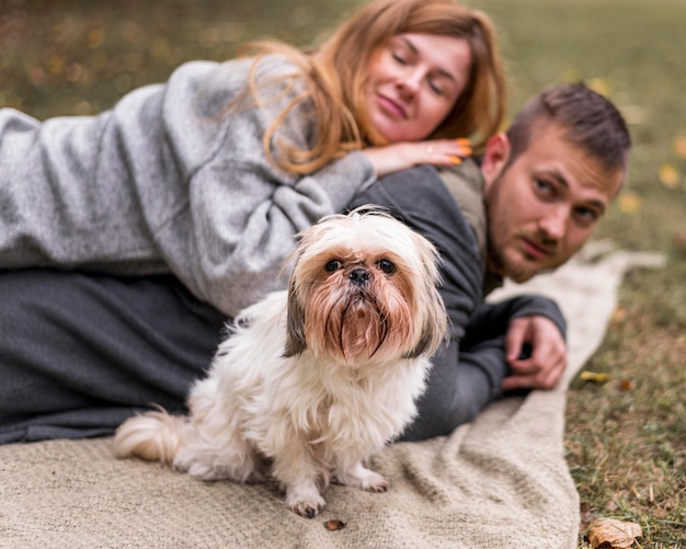 Happy family with cute dog on blanket