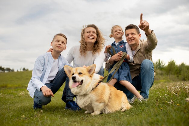 야외에서 전체 샷 강아지와 함께 행복 한 가족