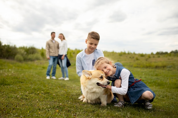 Foto gratuita famiglia felice con cane all'aperto