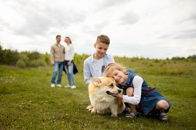 Счастливая семья с собакой на открытом воздухе
