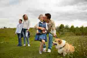 Free photo happy family with dog outside full shot