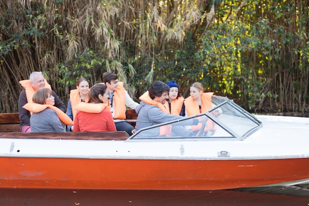 Happy family with life vests sailing on the river