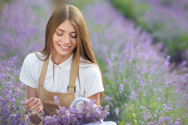 Happy farm girl with flowers basket lavender field