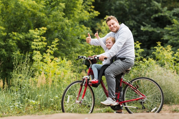 Счастливый отец и дочь на велосипеде