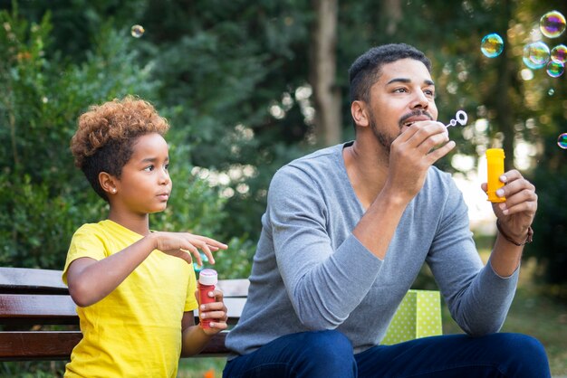 Happy father and daughter blowing soap bubbles