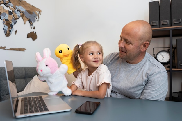 Free photo happy father and daughter playing with puppets