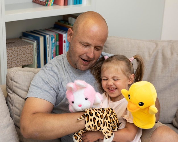 Счастливый отец и дочь играют с куклами