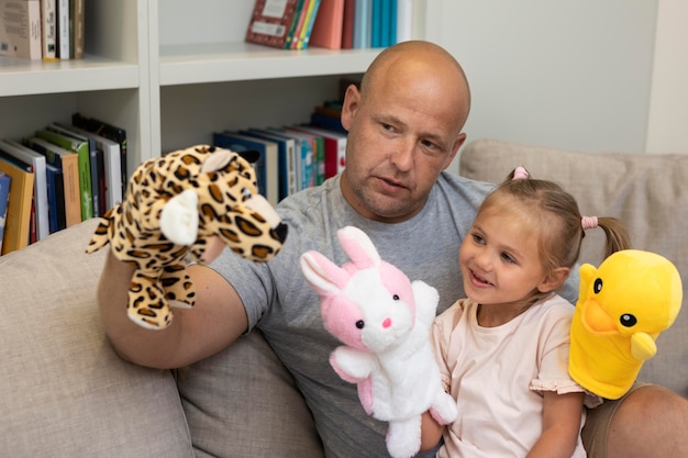 Happy father and daughter playing with puppets