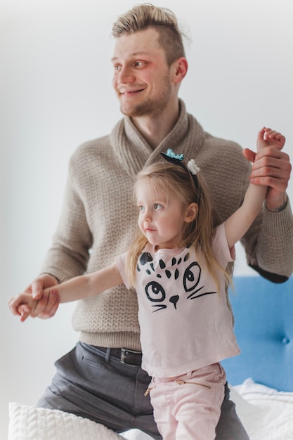 Foto gratuita padre felice che tiene le braccia di sua figlia