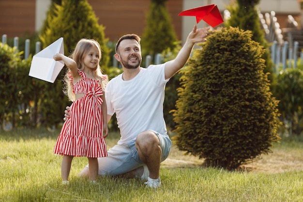 Free photo happy father playing with daughter planes outdoor