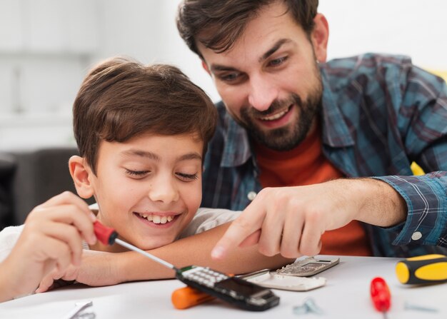 Happy father and son repairing a phone