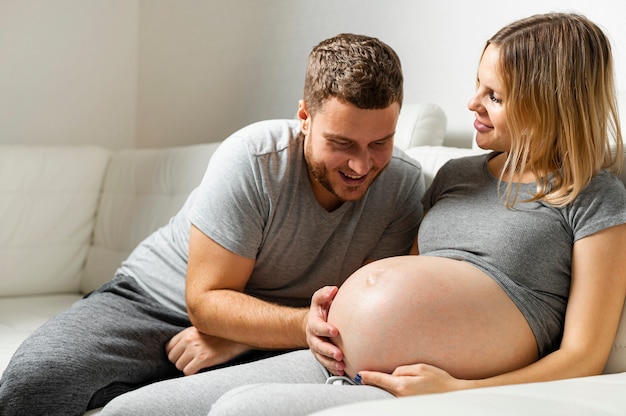 Happy father touching pregnant wife belly