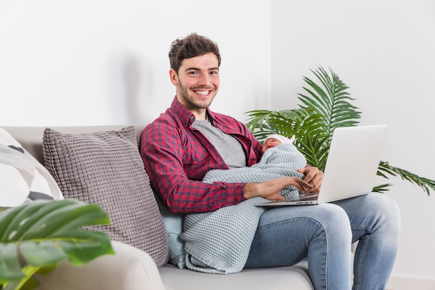 Happy father with baby using laptop 