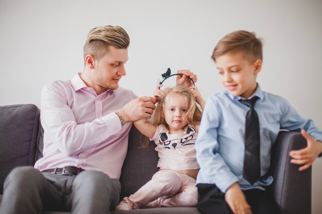 Happy father with his children on the couch