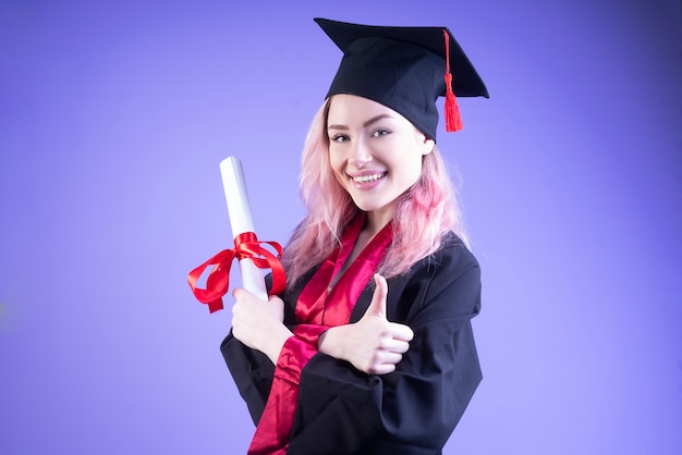 卒業帽で幸せな女性の学士は彼女の腕を組んだ