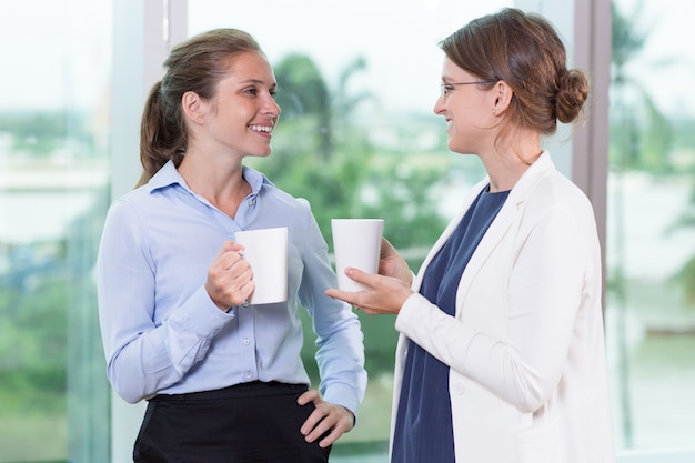 Felice colleghi femminili bere il tè e parlare