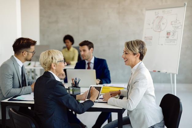 Happy female colleagues talking during business meeting in the office