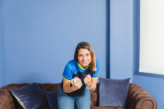 Free photo happy female football fan on couch