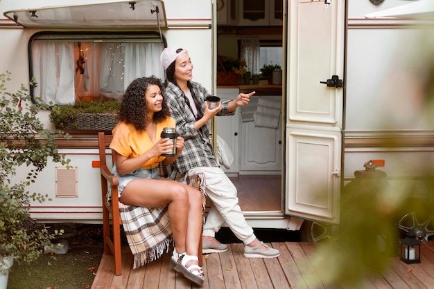 Happy female friends and camper van