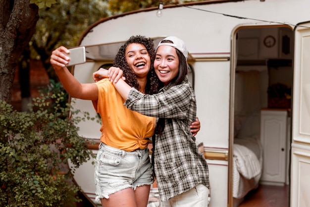 Happy female friends taking photos outdoors