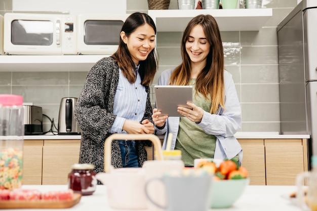 Happy female friends with tablet