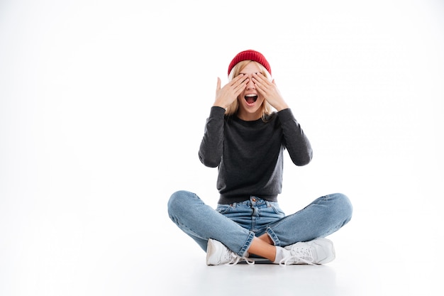 Happy female hipster covering her eyes