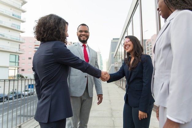 Happy female manager welcoming partners outside