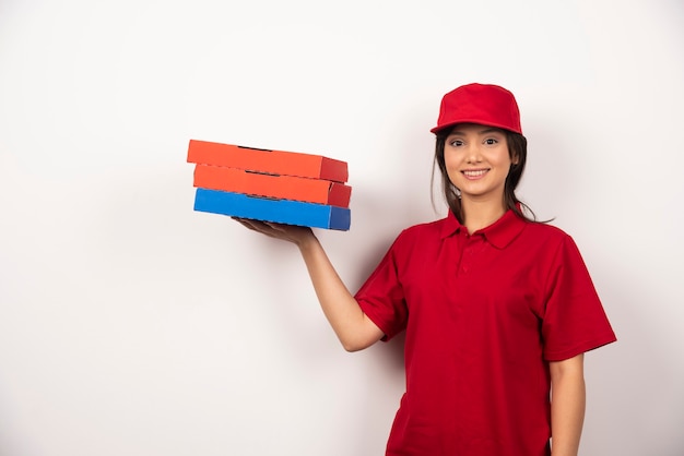無料写真 ピザの3つの段ボールで立っている幸せな女性のピザ配達労働者。