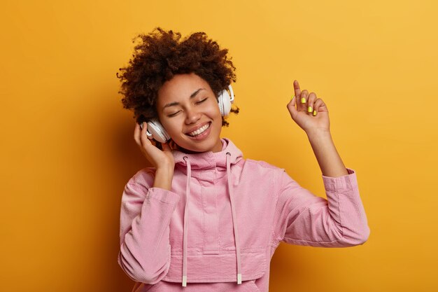 Happy female teenager enjoys pleasant music