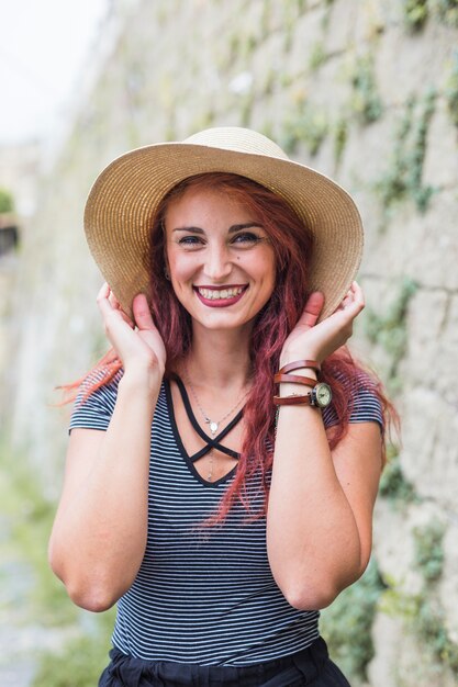 Happy female tourist next to wall