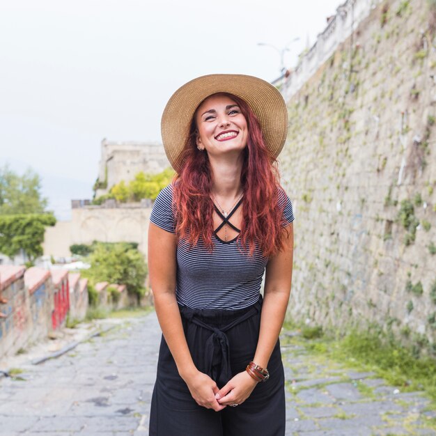 Free Photo happy female tourist next to wall