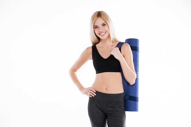 Happy fitness lady holding sports rug