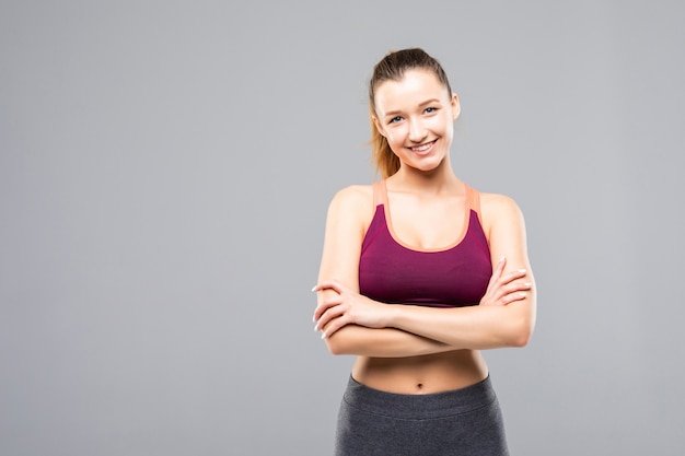 Happy fitness woman standing with arms folded