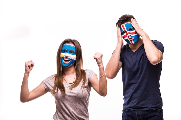 Happy Football fan of Argentina celebrate win over upset football fan of Iceland with painted face isolated on white background