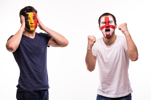 Happy Football fan of England celebrate win over upset football fan of Belgium with painted face isolated on white background