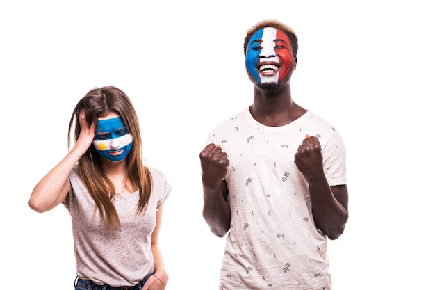 Foto gratuita felice tifoso di calcio della francia festeggia la vittoria sul tifoso arrabbiato dell'argentina con la faccia dipinta