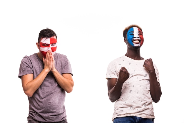 フランスの幸せなサッカーファンは、白い背景で隔離の塗られた顔でクロアチアの動揺したサッカーファンの勝利を祝う