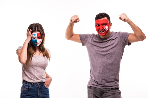 Happy Football fan of Tunisia celebrate win over upset football fan of Panama with painted face isolated on white background