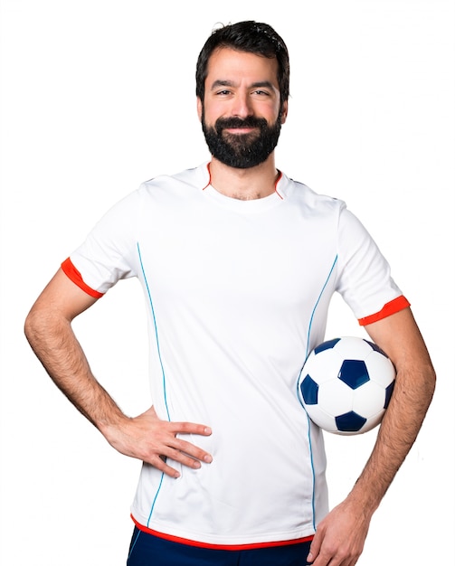 Foto gratuita felice giocatore di calcio in possesso di una pallina da calcio