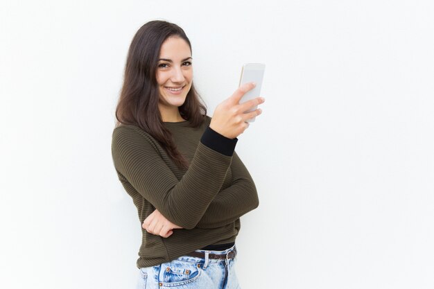 Happy friendly beautiful woman holding cellphone