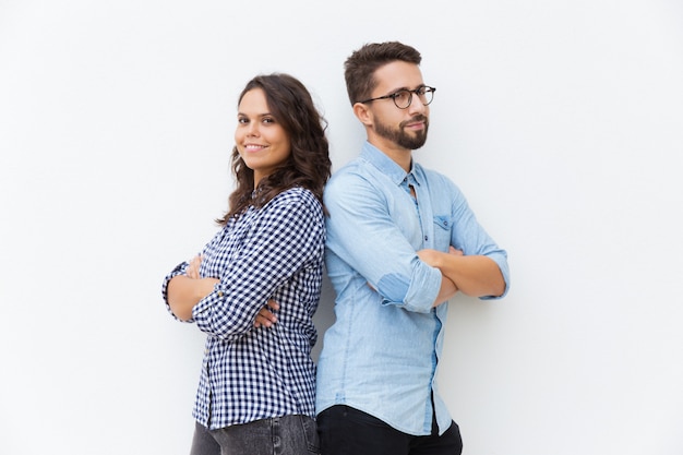 Happy friendly couple standing back-to-back