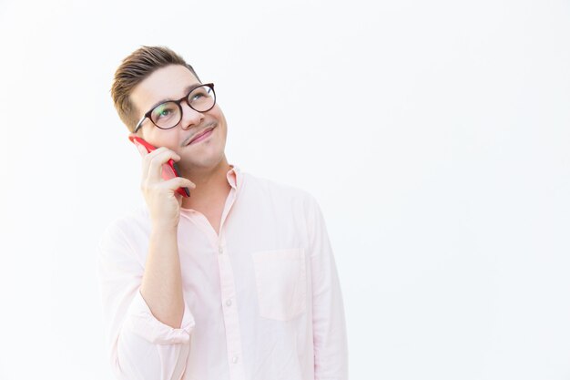 Happy friendly guy in eyewear talking on cell