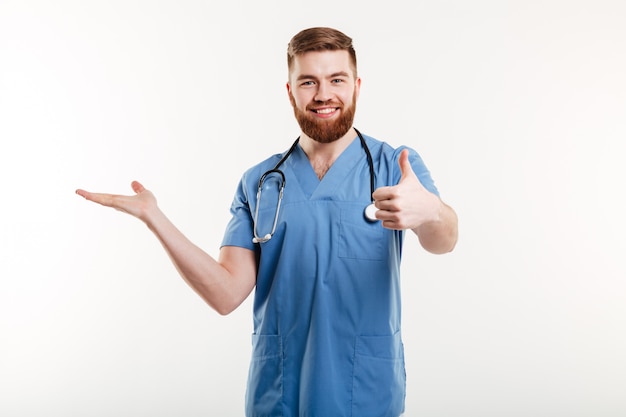 Happy friendly man doctor presenting copyspace on his palm