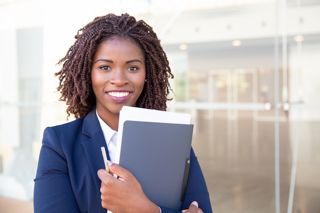 Happy friendly office assistant posing outside